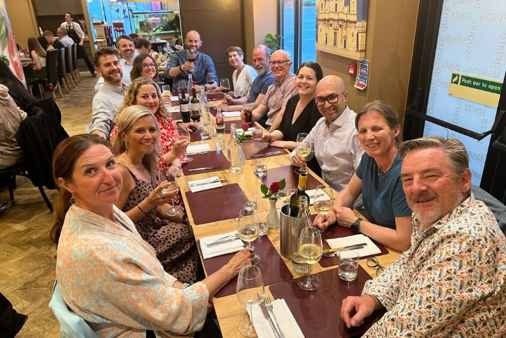 Course directors and supervisors sat at a long table in a restaurant waiting for their post workshop dinner