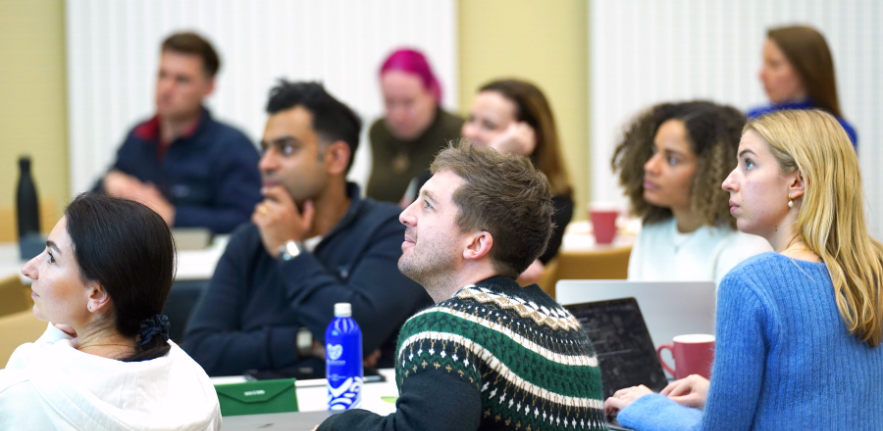 Postgraduate Students workshop A group of students looking off camera towards a presentation