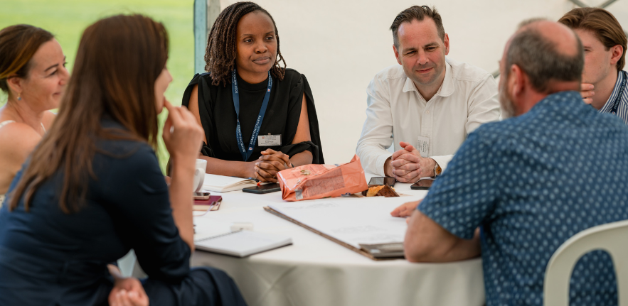Postgraduate Sustainable Business students A group of students sat around a round table in a gazibo