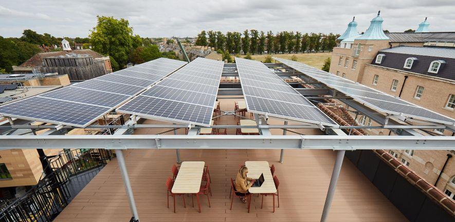 Solar panels on roof of Entopia Building, with person working at table underneath