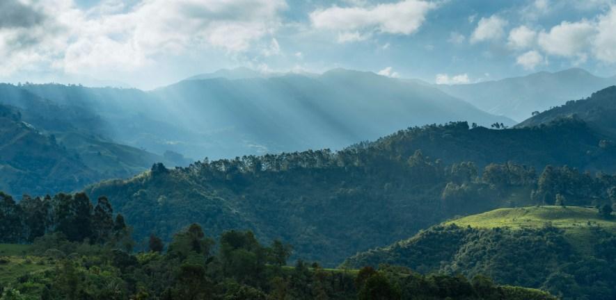 Forest and mountains in Colombia with sun shining through clouds