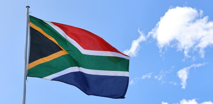 South Africa flag flying from pole, flapping in breeze